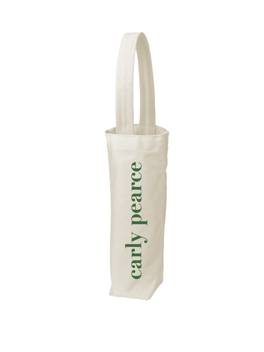 A white canvas wine tote bag with green text that reads 'carly pearce'.