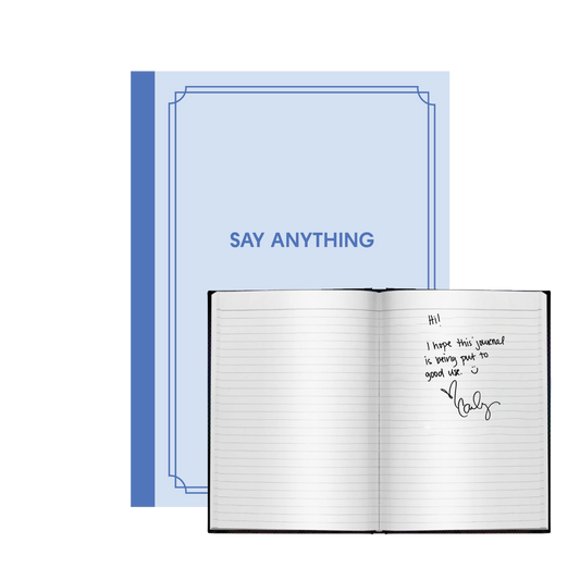 A blue journal with the title 'SAY ANYTHING' on the cover, shown open with lined pages and a signature on one page.